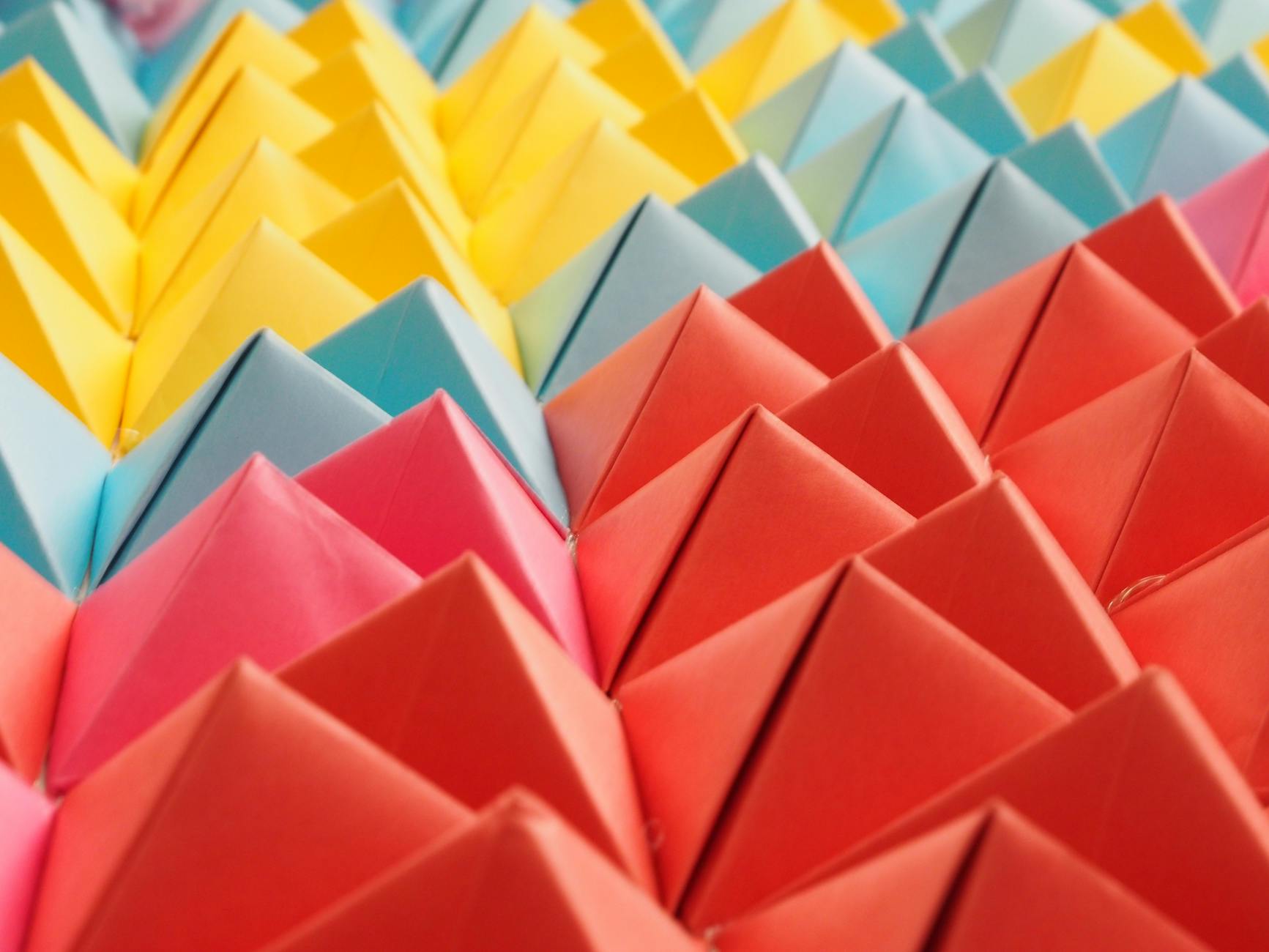 Kolorowe papierowe piramidy ułożone w geometryczny wzór origami