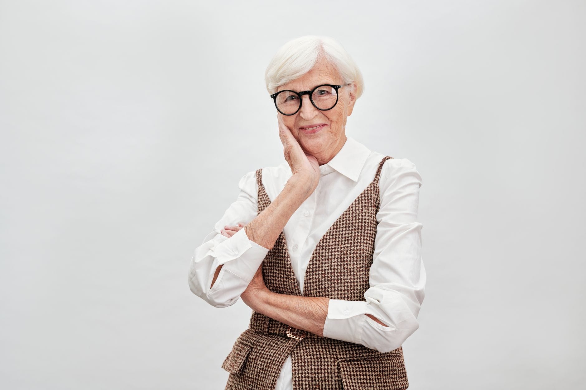 Elegancka dojrzała kobieta w okularach uśmiecha się z pewnością siebie